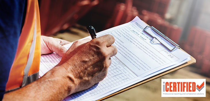building inspector filling out a building report on a clipboard